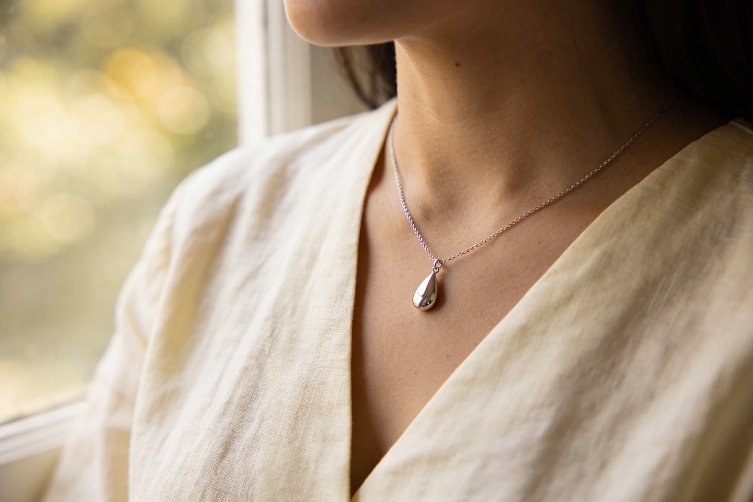Cremation necklace around a young woman's neck