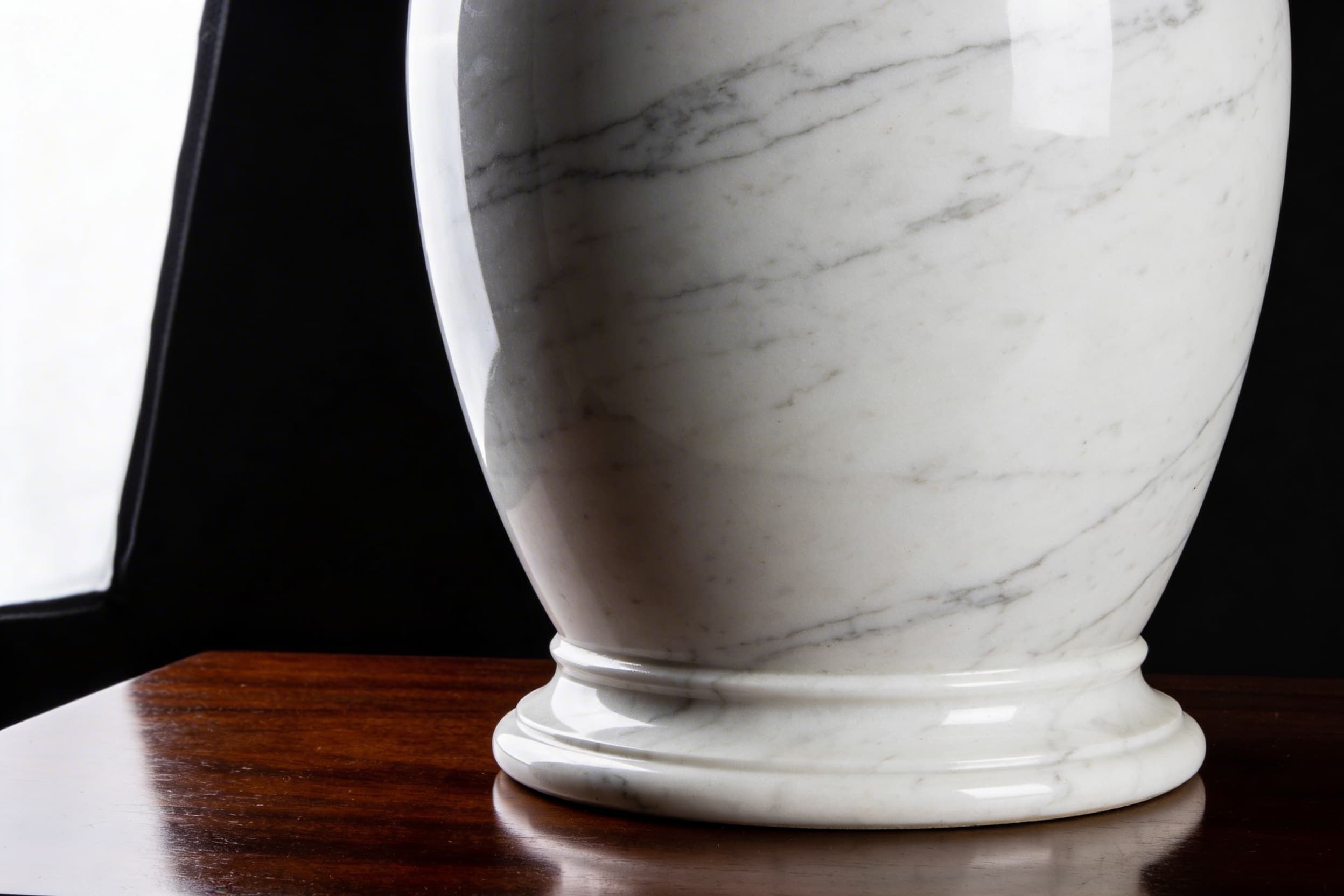 A premium large white marble pet cremation urn with subtle gray veining on polished dark wood