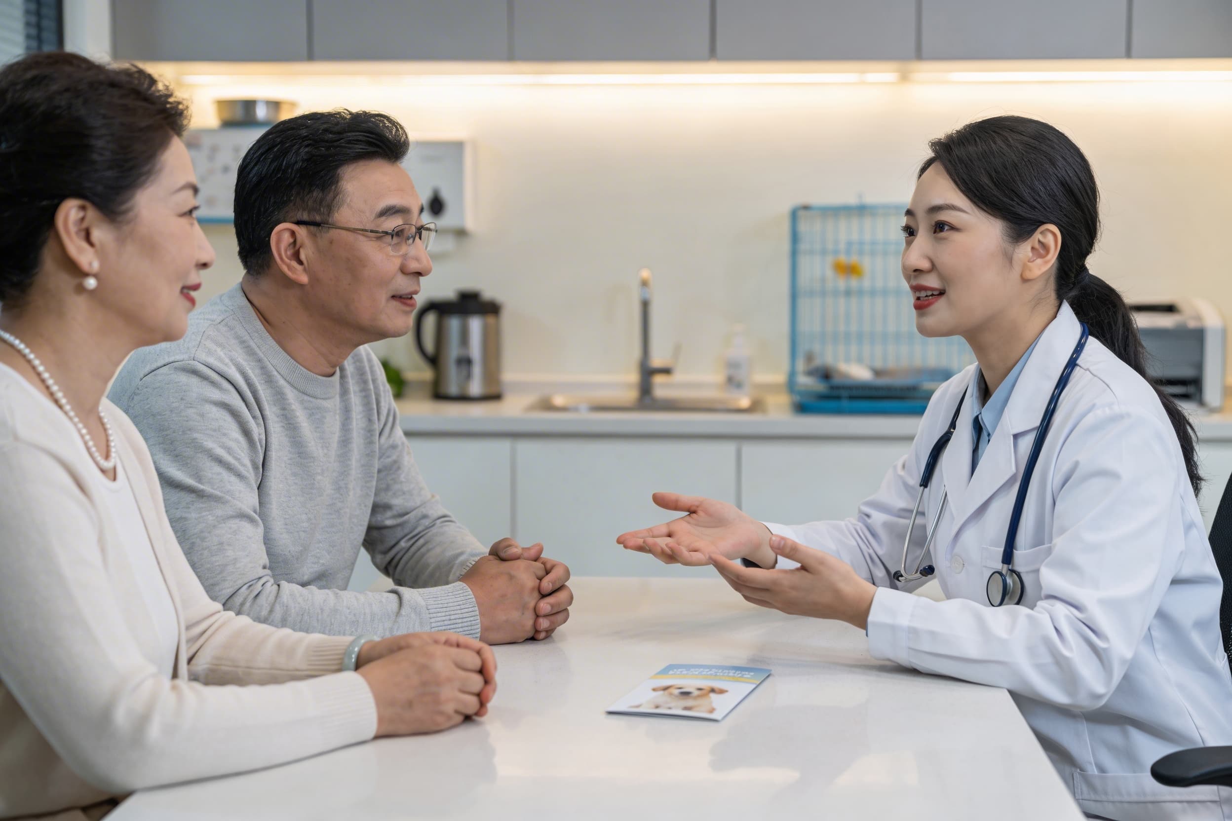A veterinarian sitting with a family in a clinic consultation room, gently discussing pet aftercare options with a brochure on the table