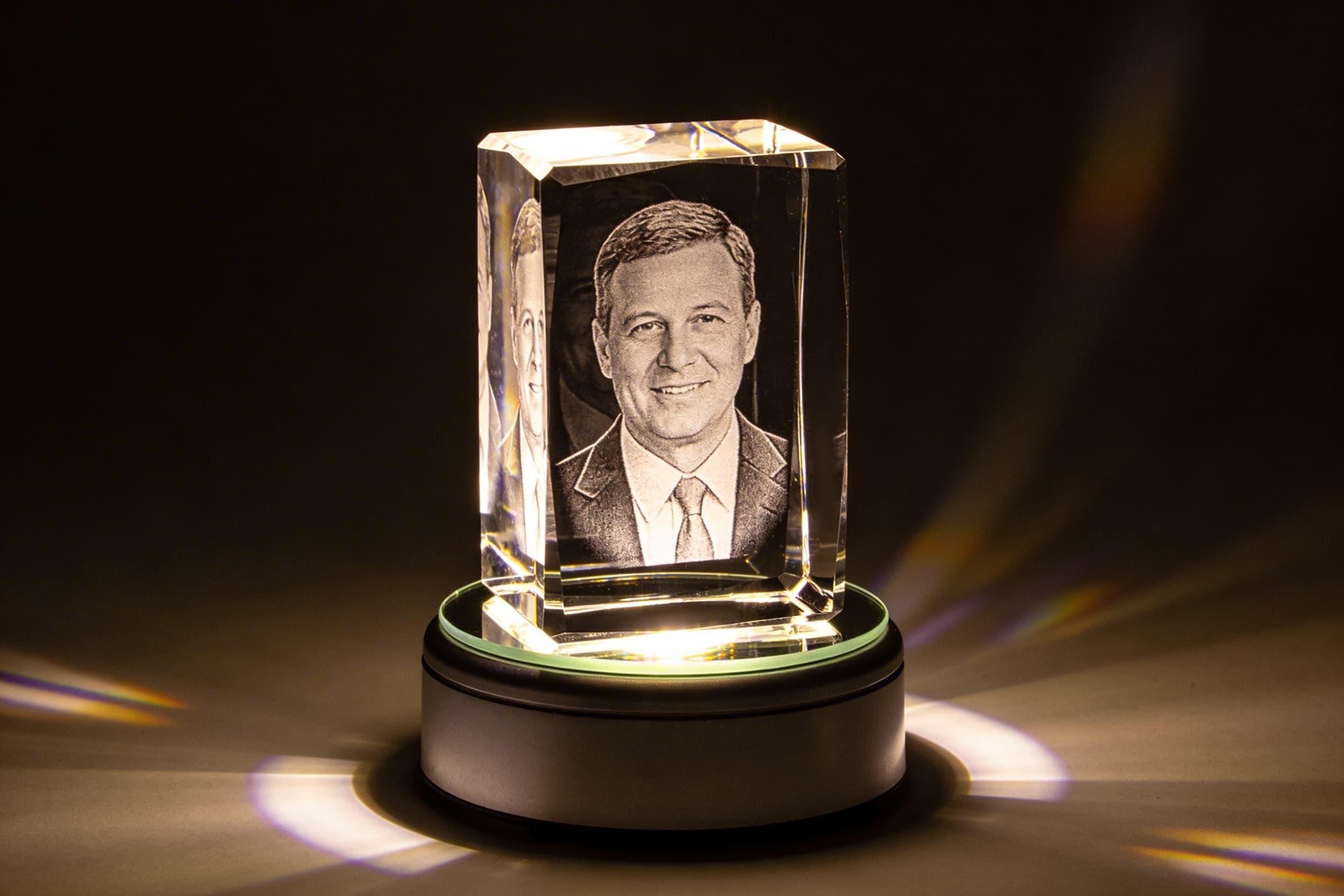 A laser-engraved crystal memorial gift displaying a loved one's portrait glowing softly on an LED light base against a dark background