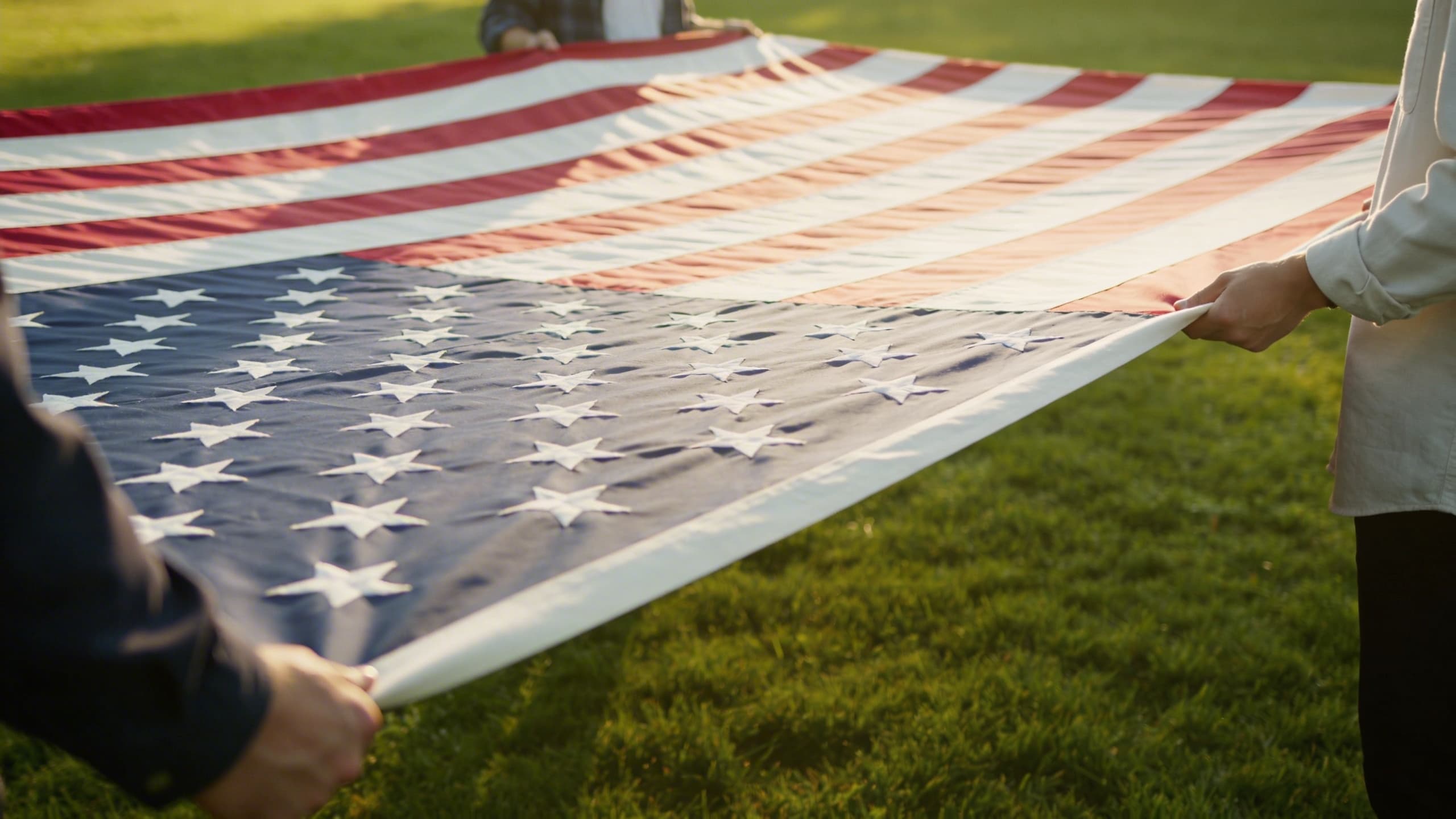 People holding an American flag taut and parallel to the ground, preparing to begin the ceremonial folding process