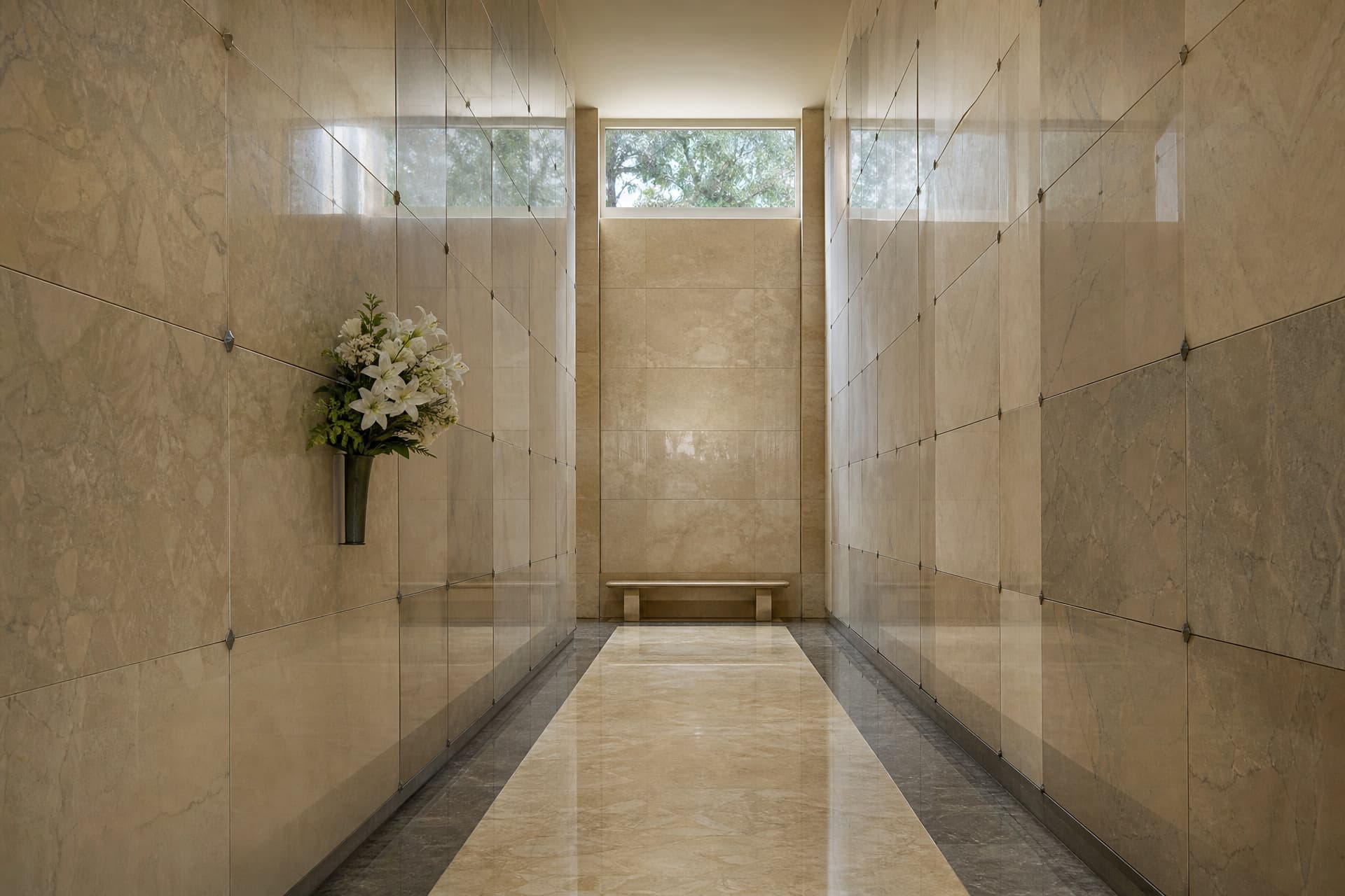 The interior corridor of a community mausoleum with polished marble walls, rows of sealed crypt fronts, and soft light from above