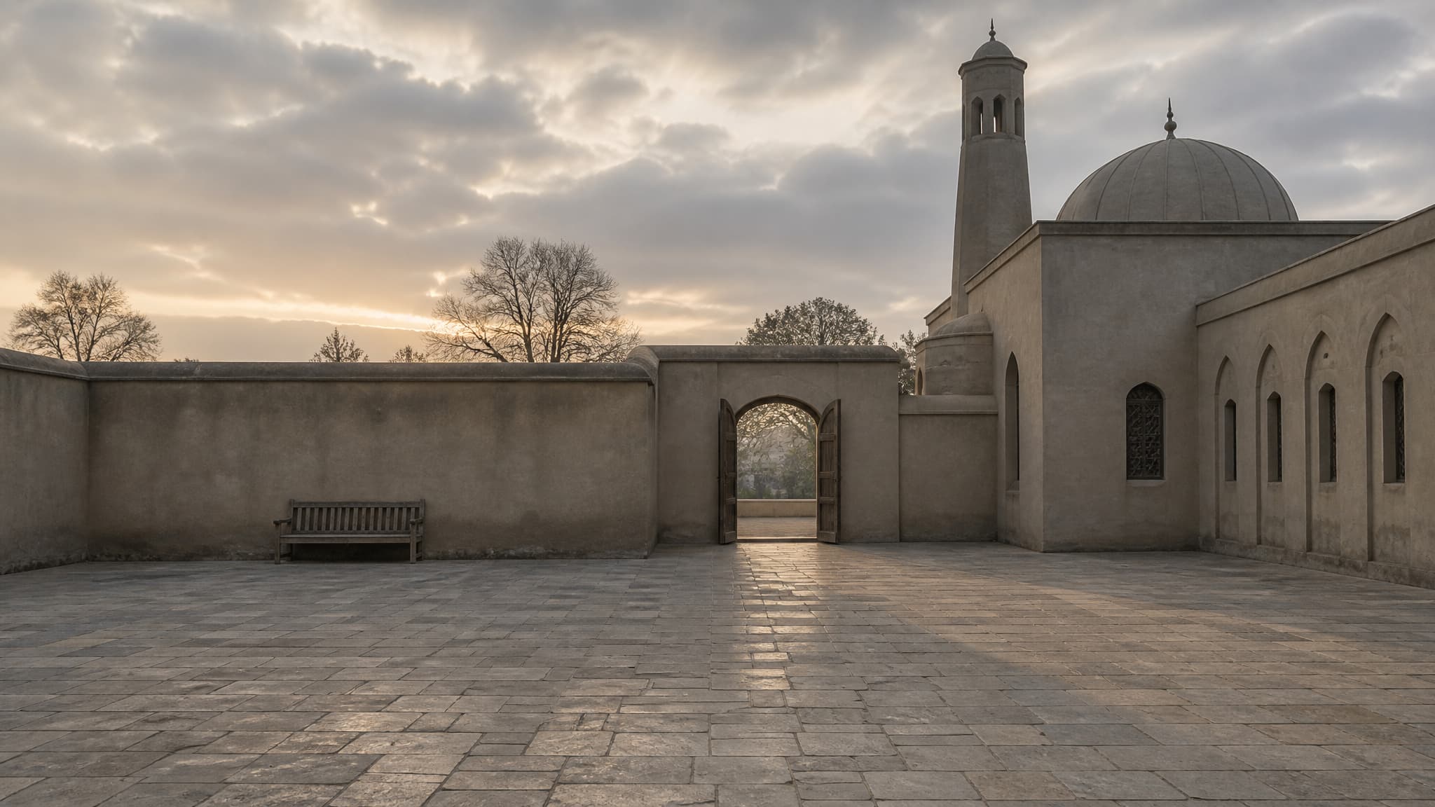 An empty mosque courtyard at first light, its doors open and the paving swept, before people arrive