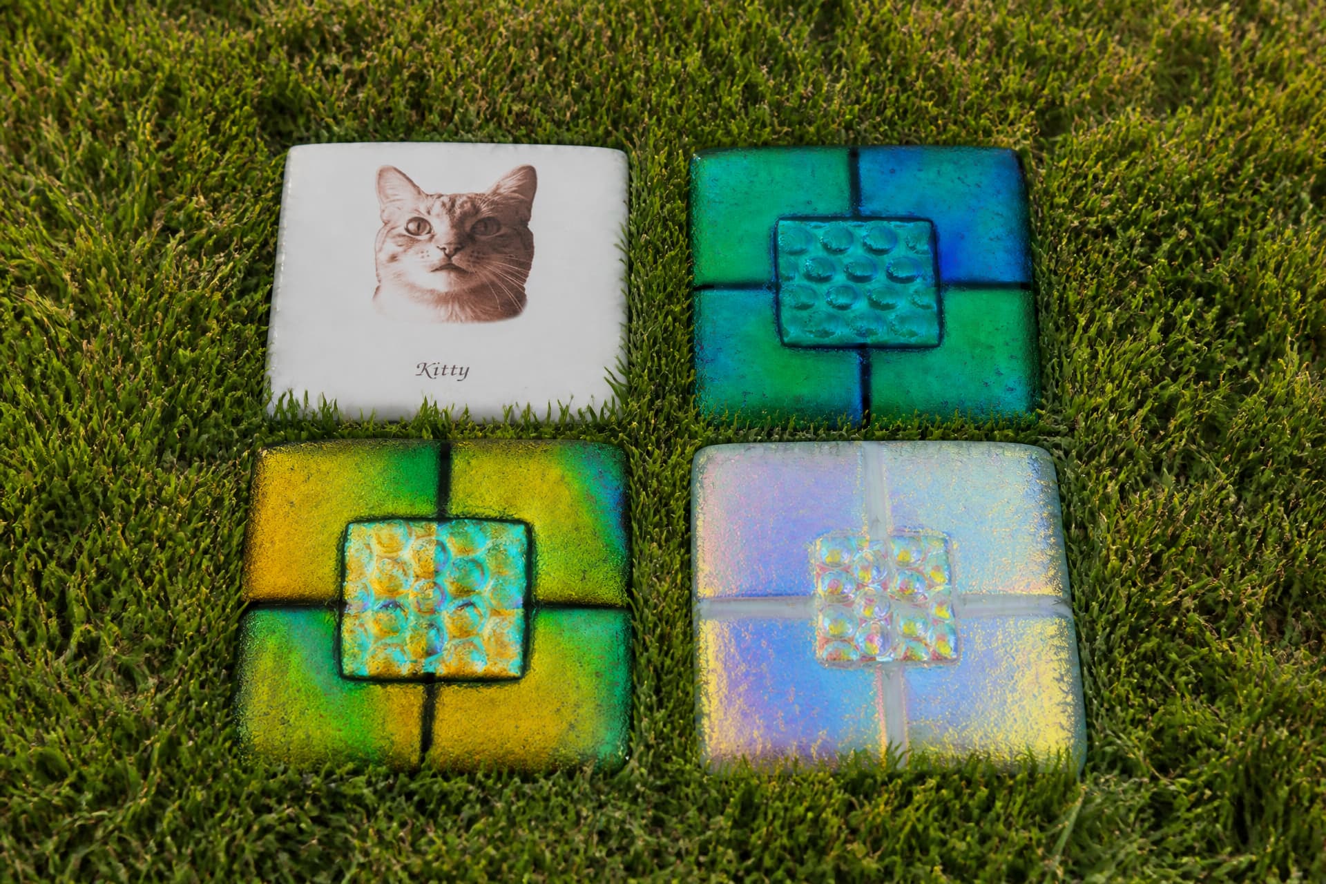 Engraved pet memorial stones and tiles arranged on a wooden surface