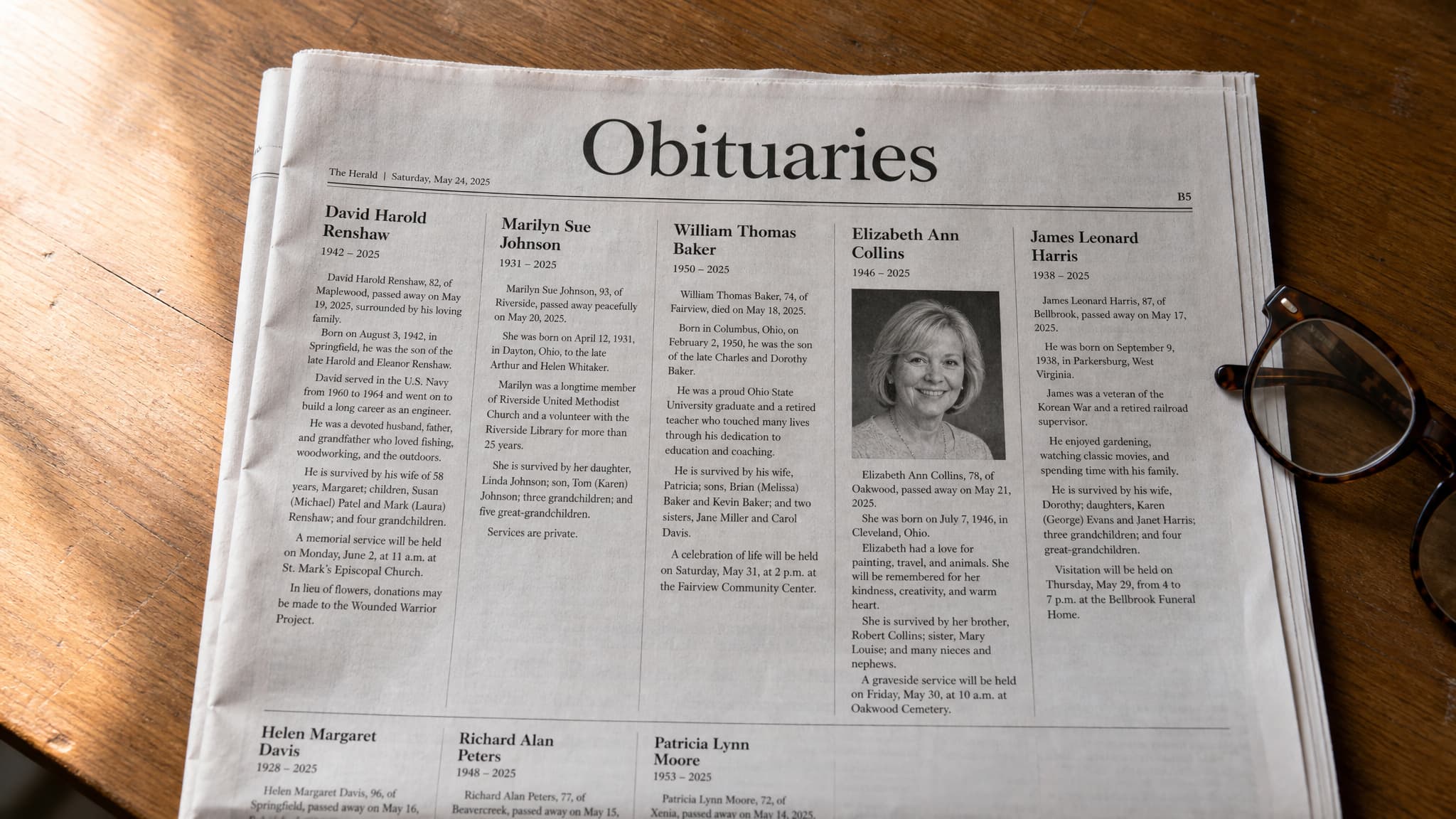 A folded broadsheet newspaper obituaries page on a wooden table seen from above at a slight angle, headed 'Obituaries' in large type with dense columns of small print below and one small portrait photograph among them