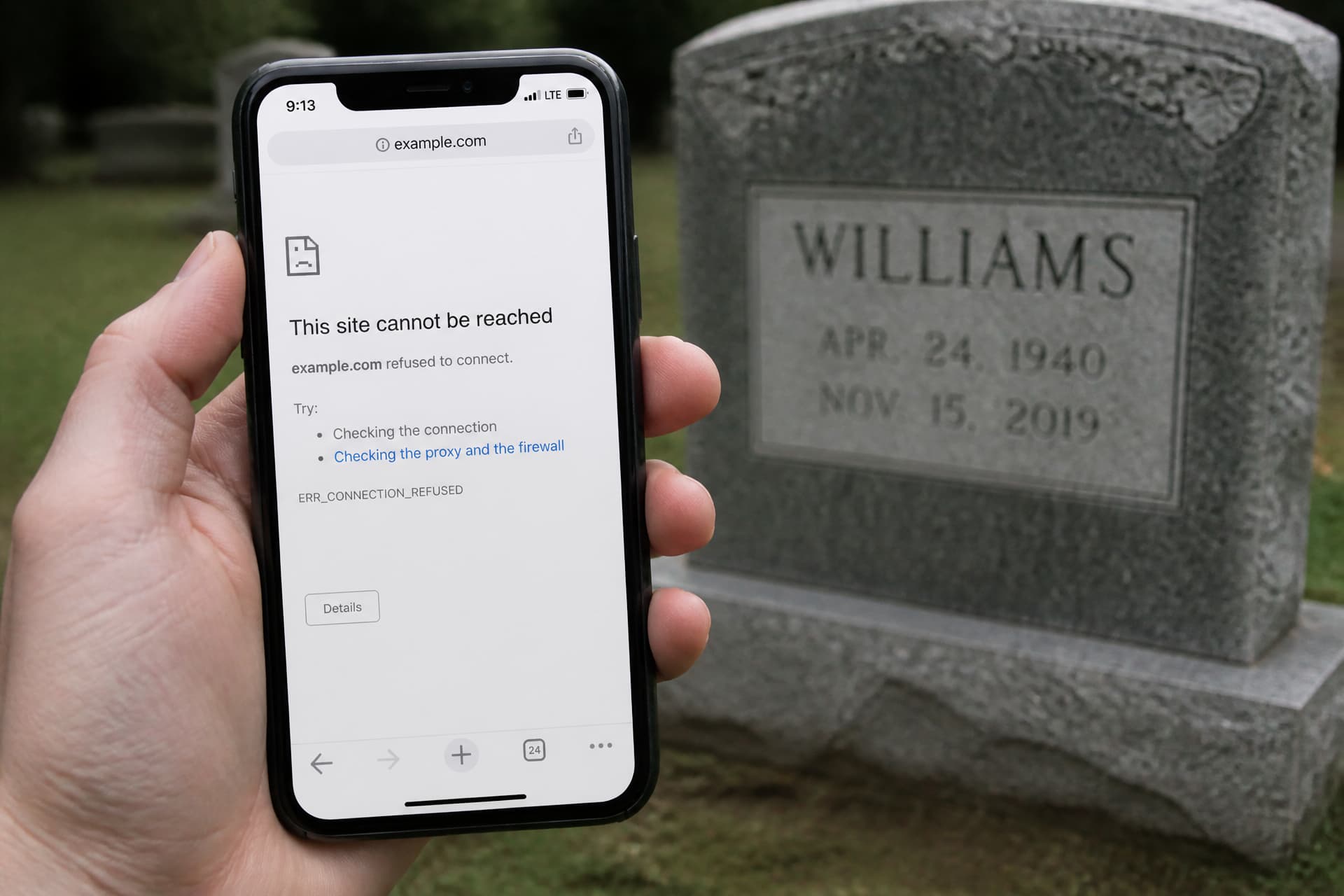 A smartphone held in one hand in front of an out-of-focus granite headstone, the screen showing a plain browser error page reading This site cannot be reached