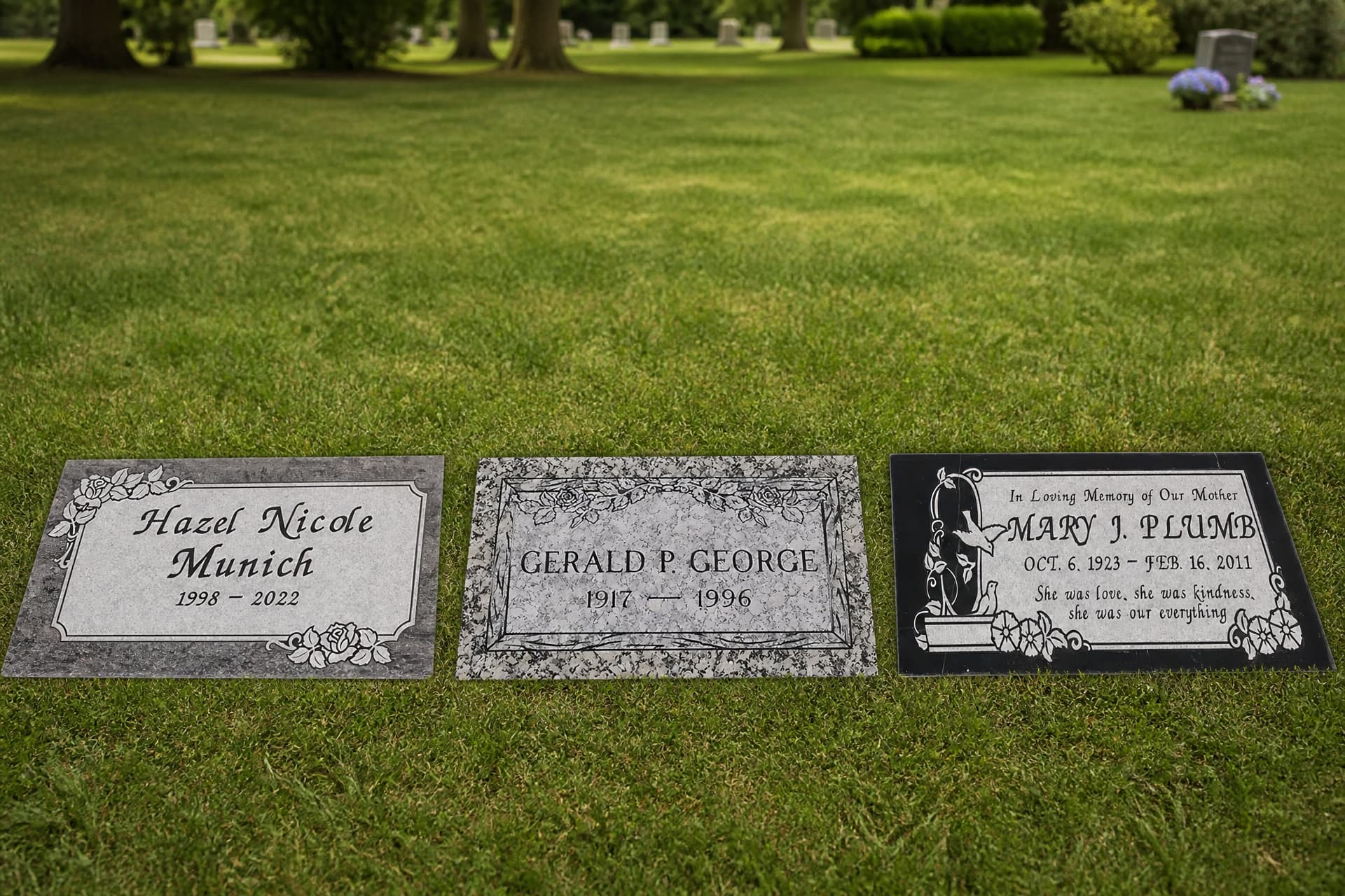 Three flat granite grave markers set level with a cemetery lawn under overcast light, one rose-cornered, one with a granite-flecked border and one in black granite with a dove and morning glories