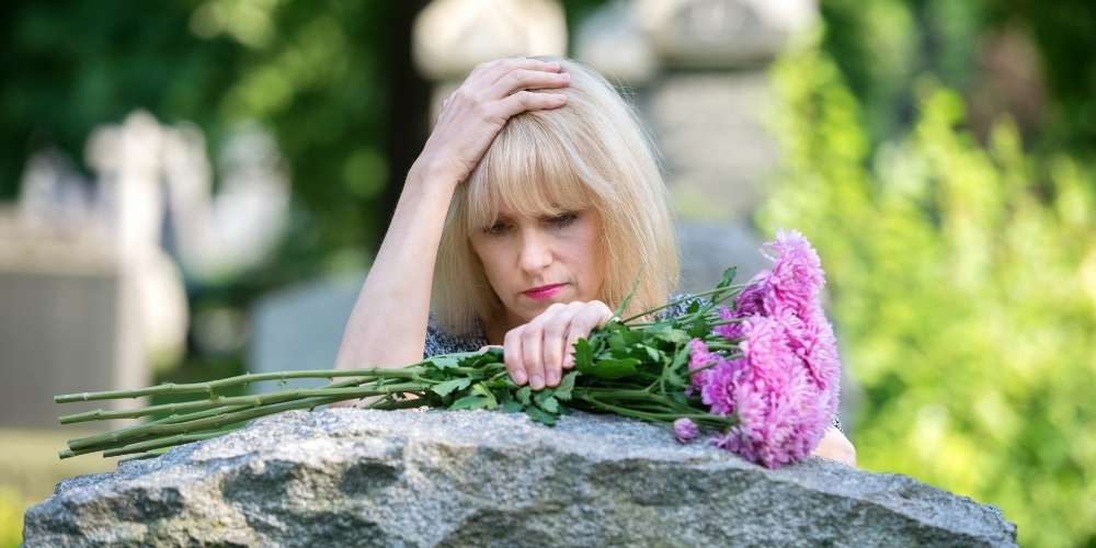 Grief Depression: Lady in cemetery at headstone